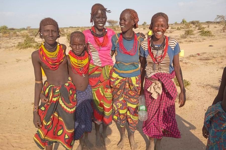 Young women in bright beadwork, smiling